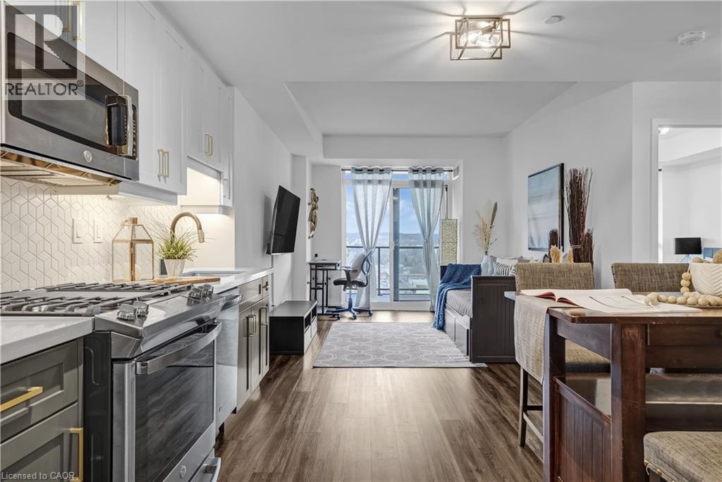 A modern kitchen with a stainless steel stove and a dining area with a wooden table.