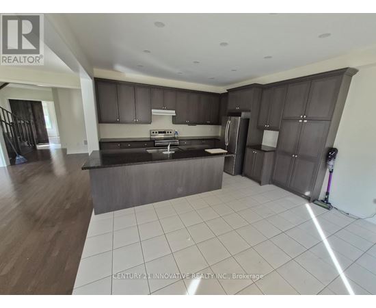 A modern kitchen with dark brown cabinets and a white tiled floor.