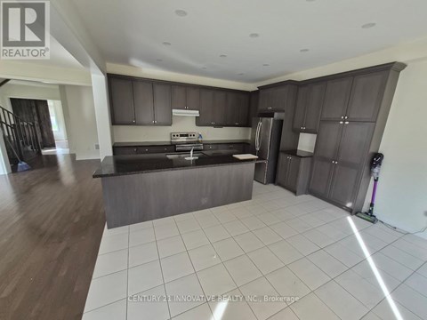 A modern kitchen with dark brown cabinets and a white tiled floor.