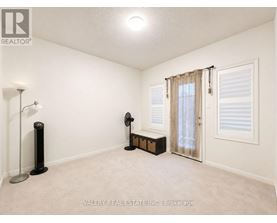 A room with a fan, a table fan, and a lamp.