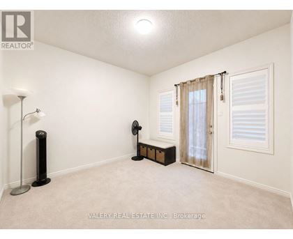 A room with a fan, a table fan, and a lamp.