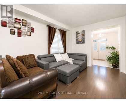 A living room with a brown leather couch and a grey sofa.