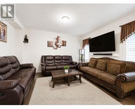 A living room with brown leather furniture and a flat screen TV mounted on the wall.