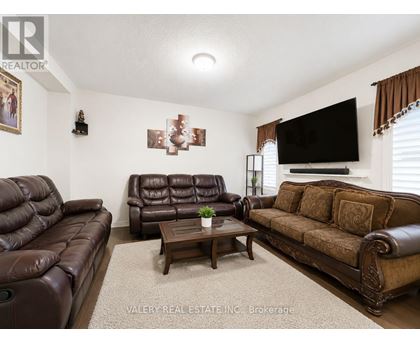 A living room with brown leather furniture and a flat screen TV mounted on the wall.