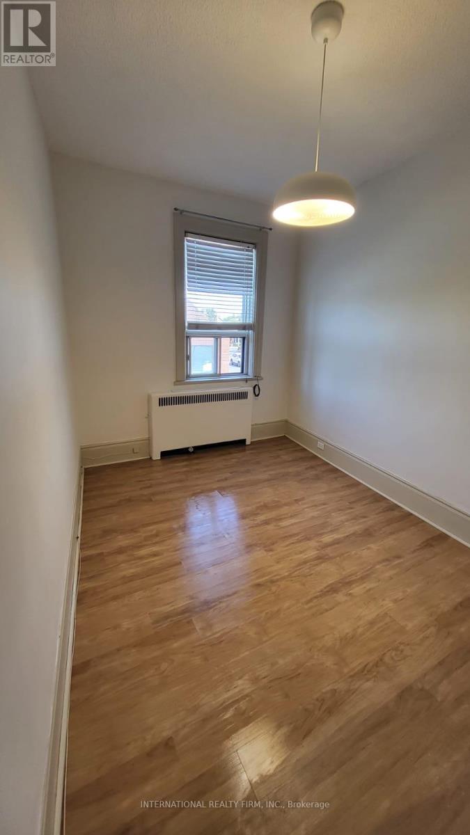 A room with wooden flooring and a window.