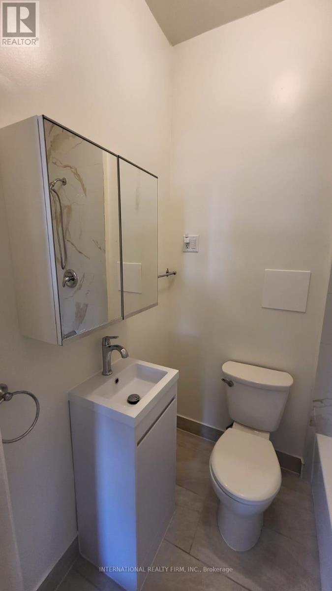A white toilet sits next to a sink in a small bathroom.