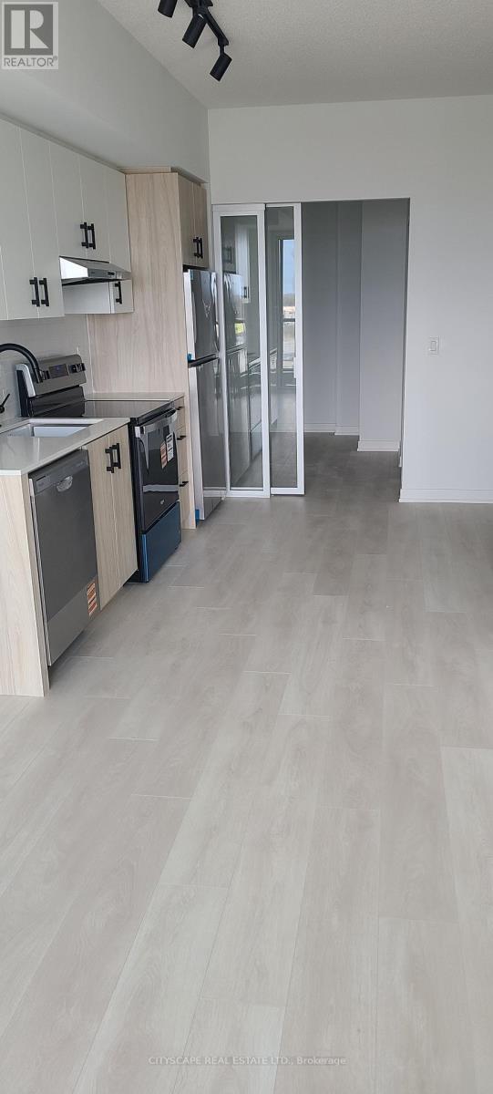 A kitchen with a refrigerator, microwave, and oven.
