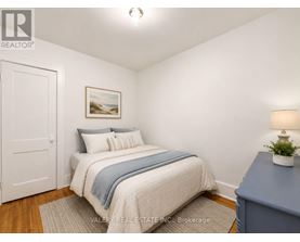 A bedroom with a bed, a lamp, and a painting on the wall.