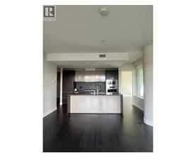 A modern kitchen with dark wood floors and white cabinetry.