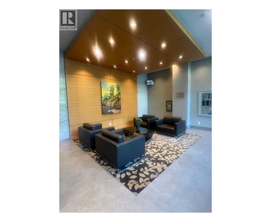 A living room with a large painting on the wall and a rug on the floor.