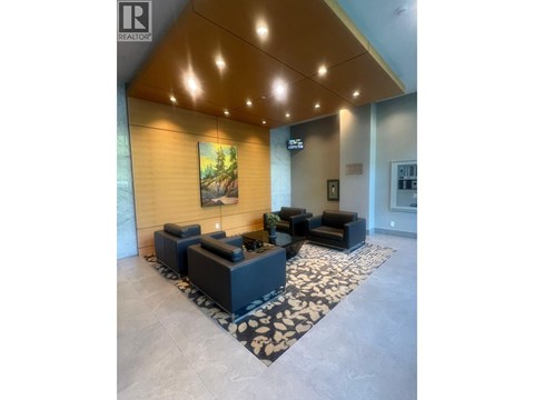 A living room with a large painting on the wall and a rug on the floor.