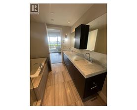 A modern bathroom with a large mirror and a double sink vanity.