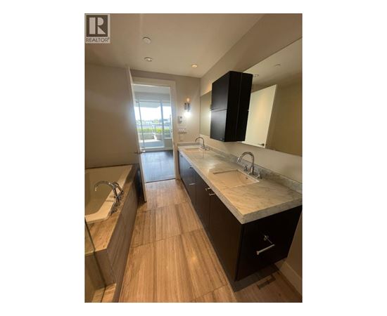 A modern bathroom with a large mirror and a double sink vanity.