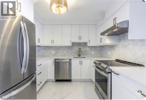 A kitchen with white cabinets and a stainless steel refrigerator.