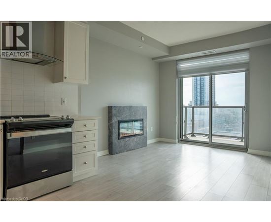 A modern kitchen with a stove top oven and a fireplace.