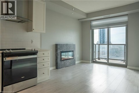 A modern kitchen with a stove top oven and a fireplace.