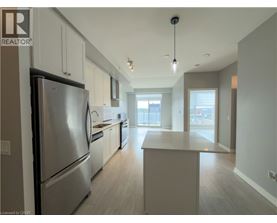 A modern kitchen with a refrigerator, cabinets, and a countertop.