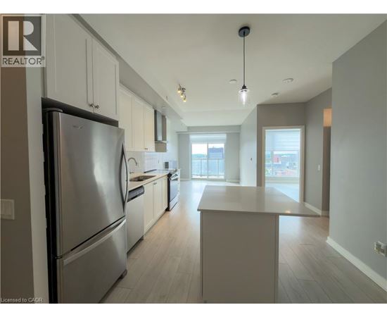 A modern kitchen with a refrigerator, cabinets, and a countertop.