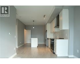A well-lit, empty kitchen with white appliances and cabinets.