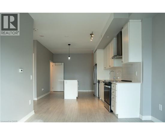 A well-lit, empty kitchen with white appliances and cabinets.