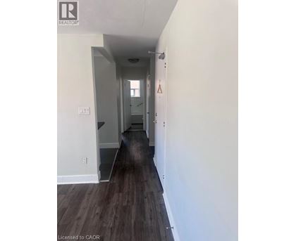 A long hallway with wood floors and white walls.