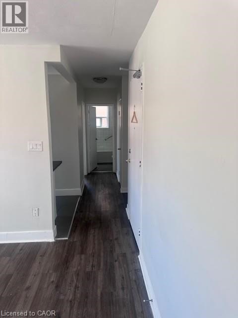 A long hallway with wood floors and white walls.