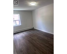 A room with wooden flooring and a window.