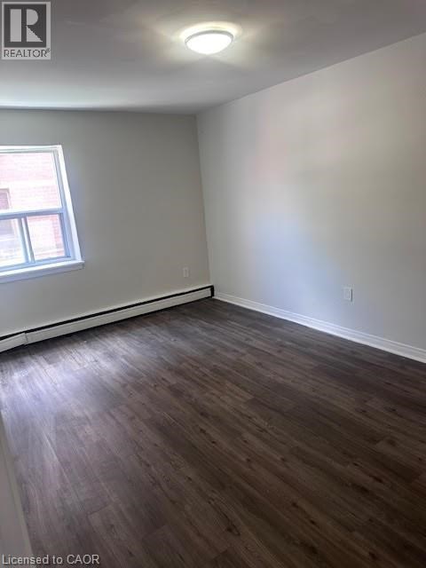 A room with wooden flooring and a window.