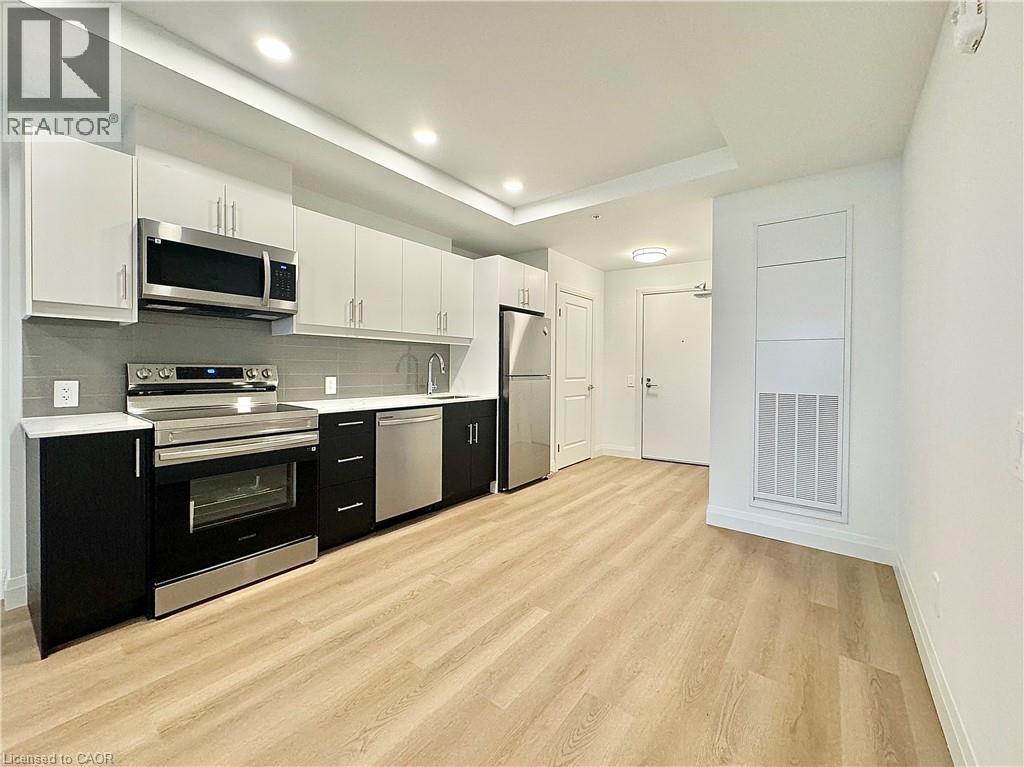 A well-lit kitchen with wooden floors and modern appliances.