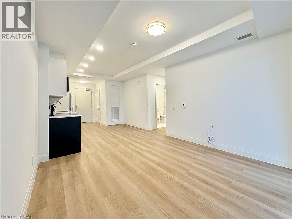 A spacious room with wooden flooring and white walls.