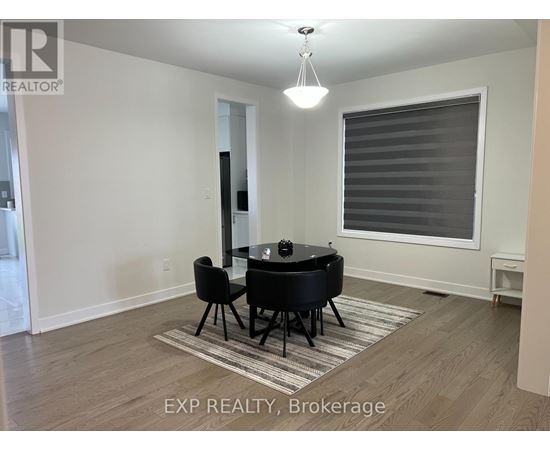 A living room with black leather furniture and a large window with blinds.