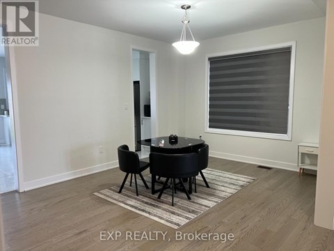 A living room with black leather furniture and a large window with blinds.