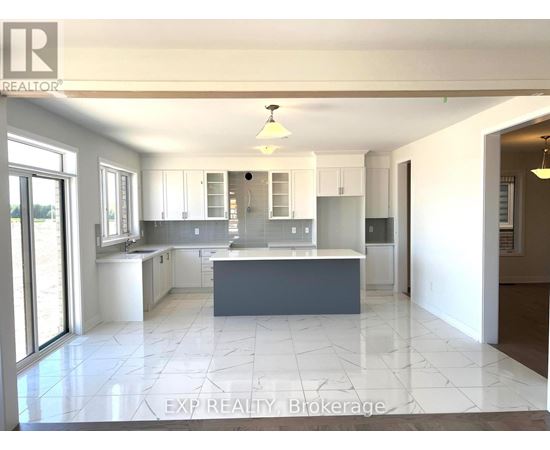 A kitchen with white cabinets and a large island.