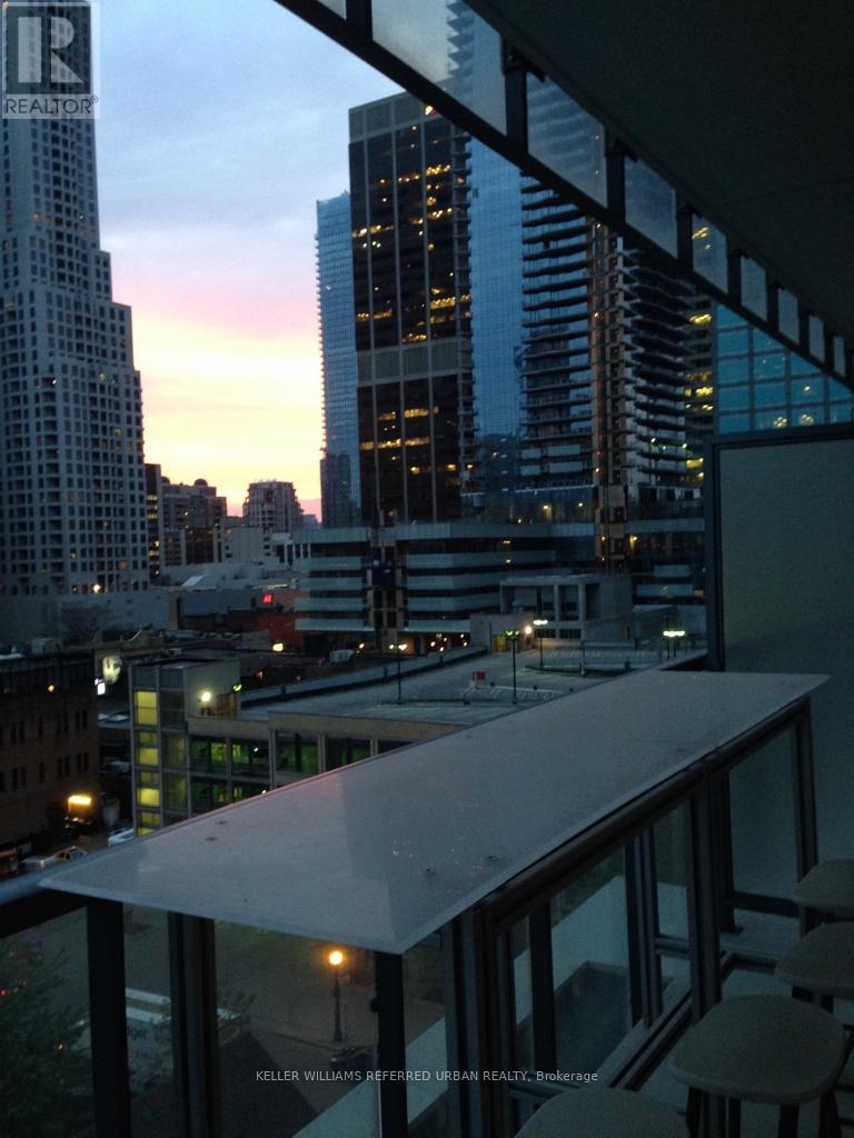 A cityscape at dusk with a building in the foreground.
