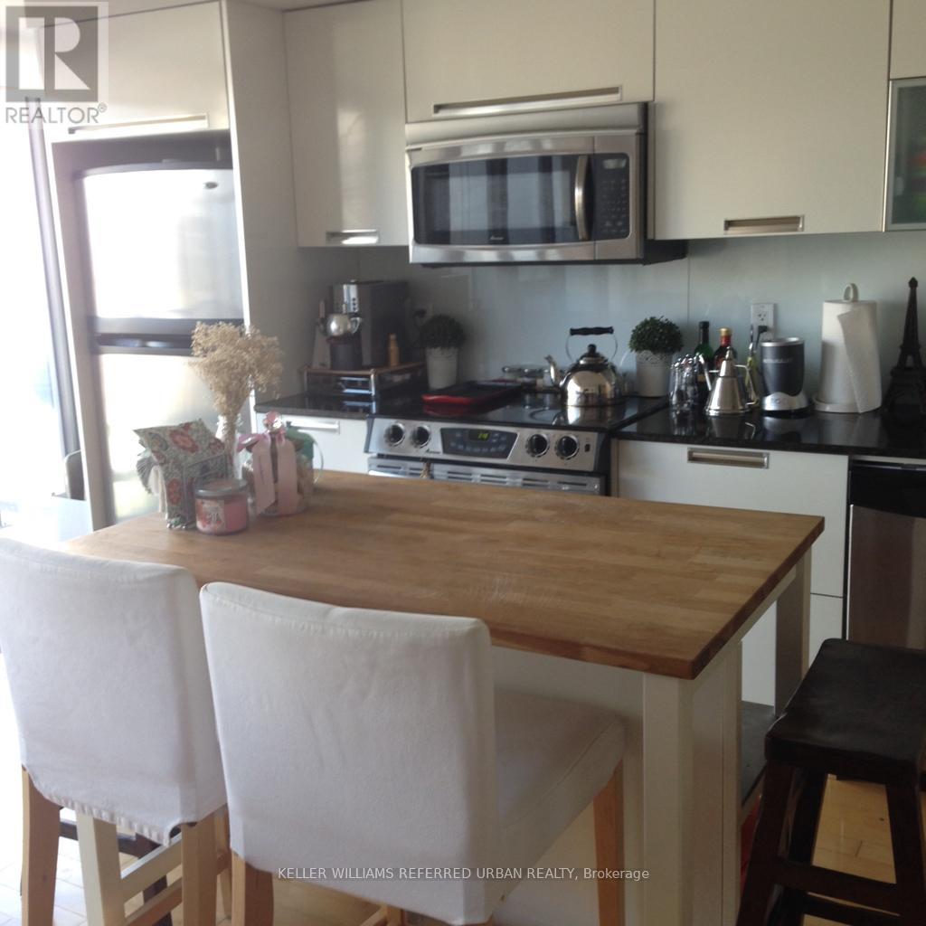 A kitchen with a wooden table and white chairs.