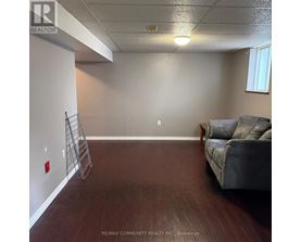 A room with a grey couch and a wooden floor.