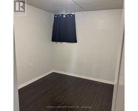 A room with a dark curtain and a light switch on the wall.