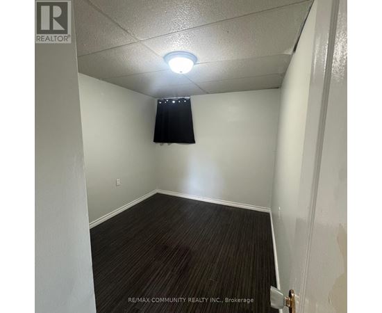 A room with a dark curtain and a light switch on the wall.