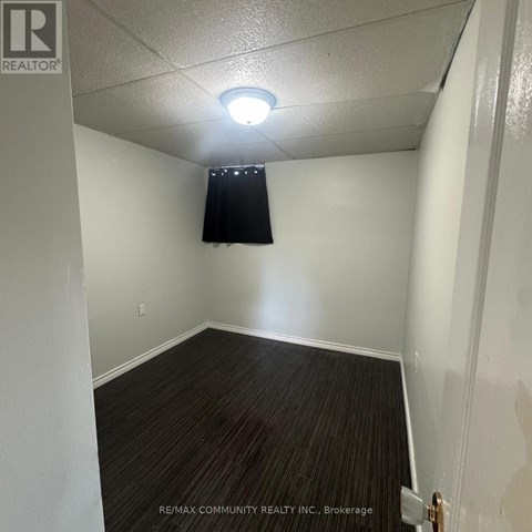 A room with a dark curtain and a light switch on the wall.
