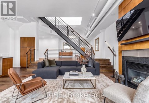 A living room with a grey couch and a wooden chair.