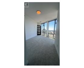 A room with a carpeted floor and a large window overlooking a cityscape.