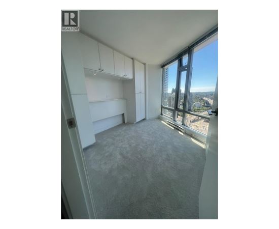 A room with a large window overlooking a cityscape.