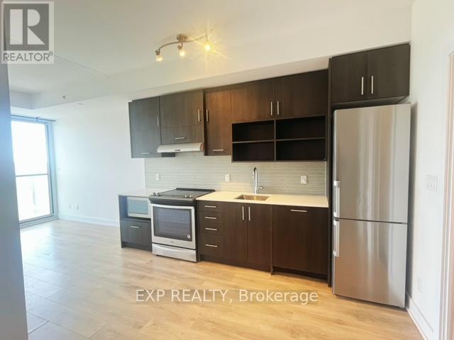 A kitchen with dark brown cabinets and stainless steel appliances.