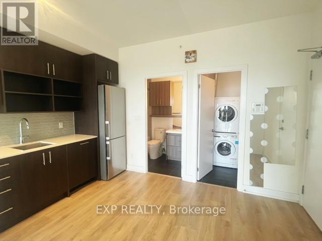 A kitchen with dark brown cabinets and a white fridge.