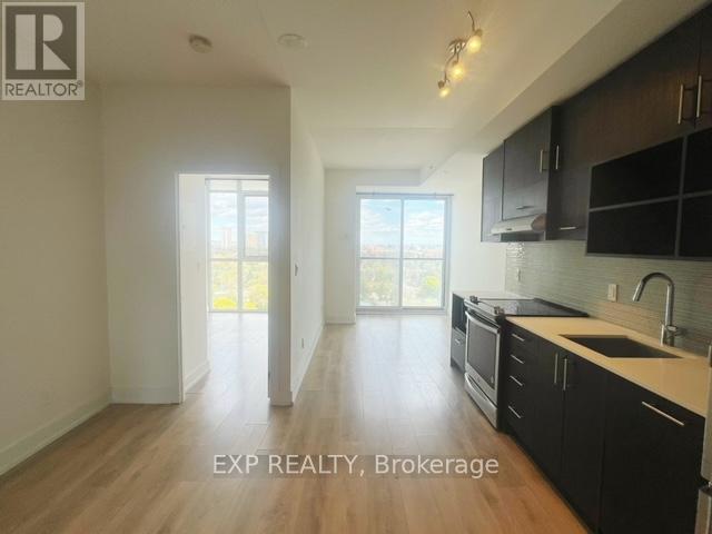 A kitchen with black cabinets and a sink is shown in the image.