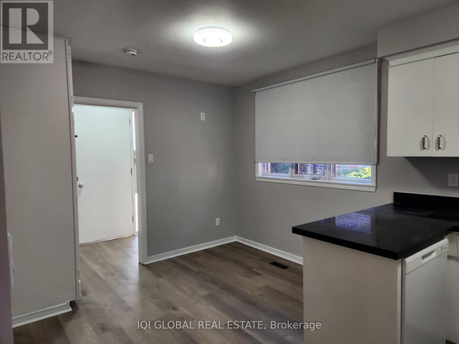 A kitchen with a black countertop and white cabinets.