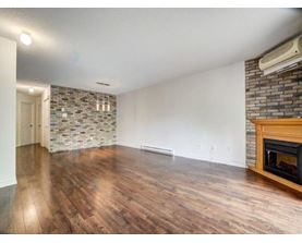 A room with a fireplace and a stone wall.