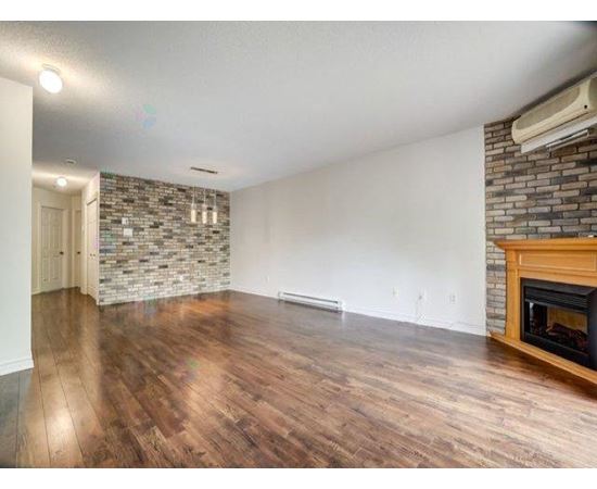 A room with a fireplace and a stone wall.