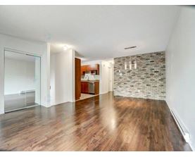 A room with wooden floors and a stone wall.