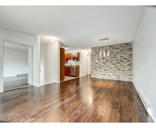 A room with wooden floors and a stone wall.